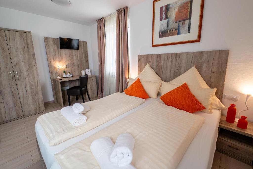 a bedroom with a large bed with towels on it at Hotel Lichtblick Salach in Salach
