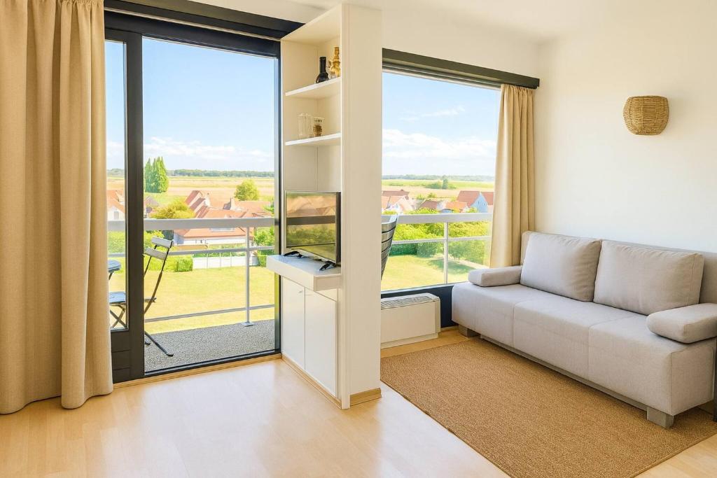 a living room with a couch and a large window at Parking gratuit, piscine intérieur vue panoramique in Heist
