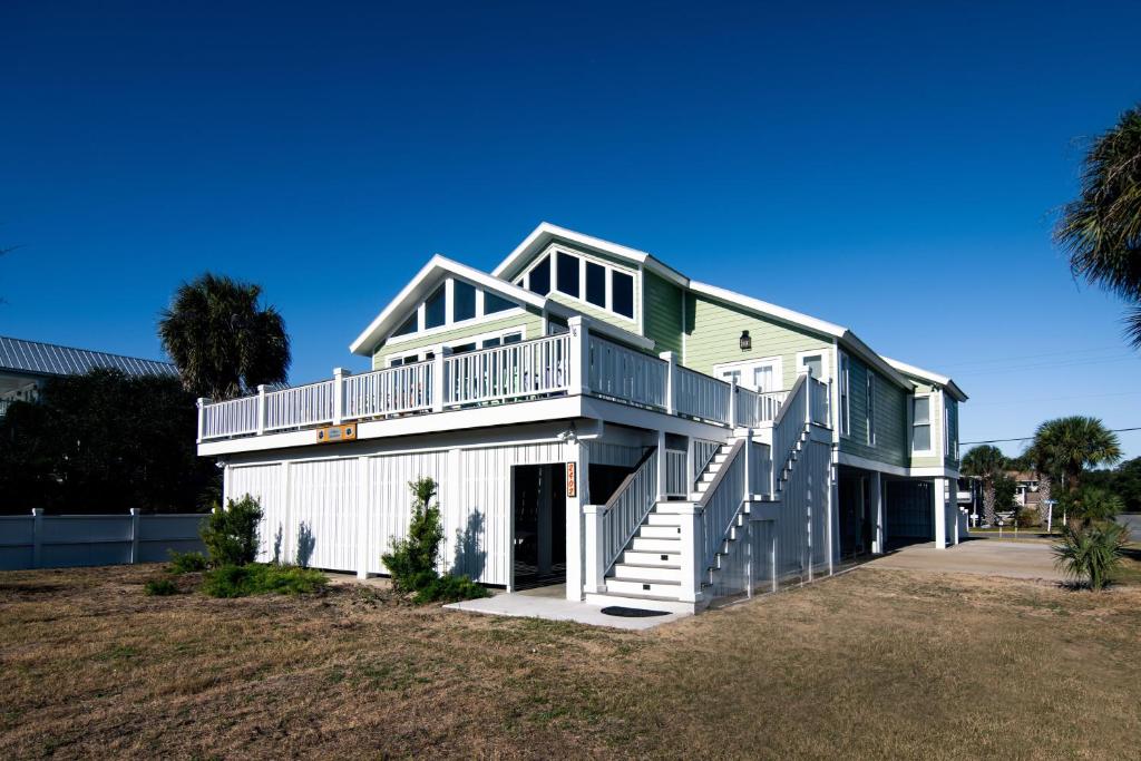 a green and white house with a balcony at A Shore Investment in Edisto Island