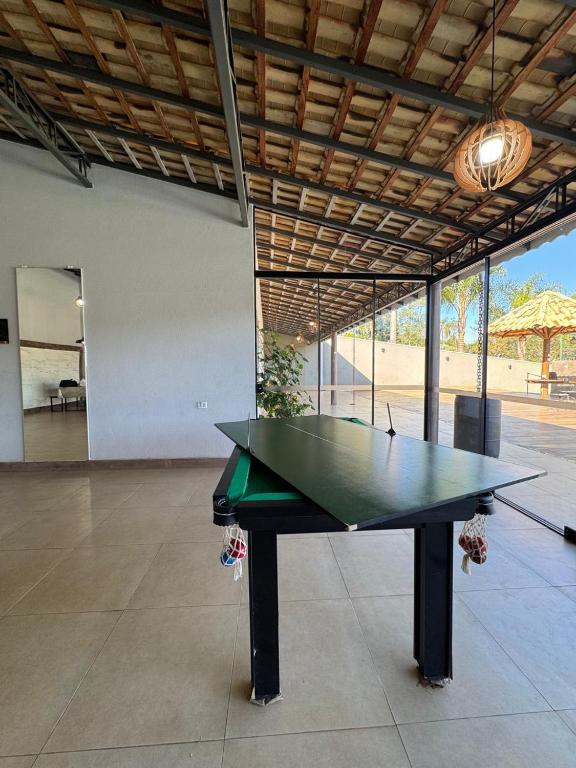 a ping pong table in the middle of a room at Chácara Conquistando II in Jarinu