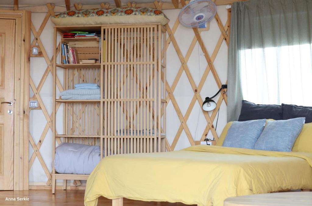 a bedroom with a bed and a book shelf at היורט על הגג - צוקים in Zuqim