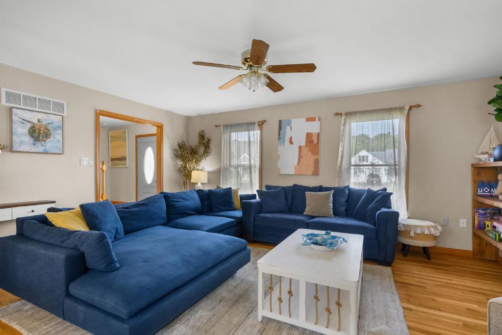 ein Wohnzimmer mit blauen Sofas und einem Deckenventilator in der Unterkunft 26 Old Carriage Drive Harwich - The Carriage House in East Harwich