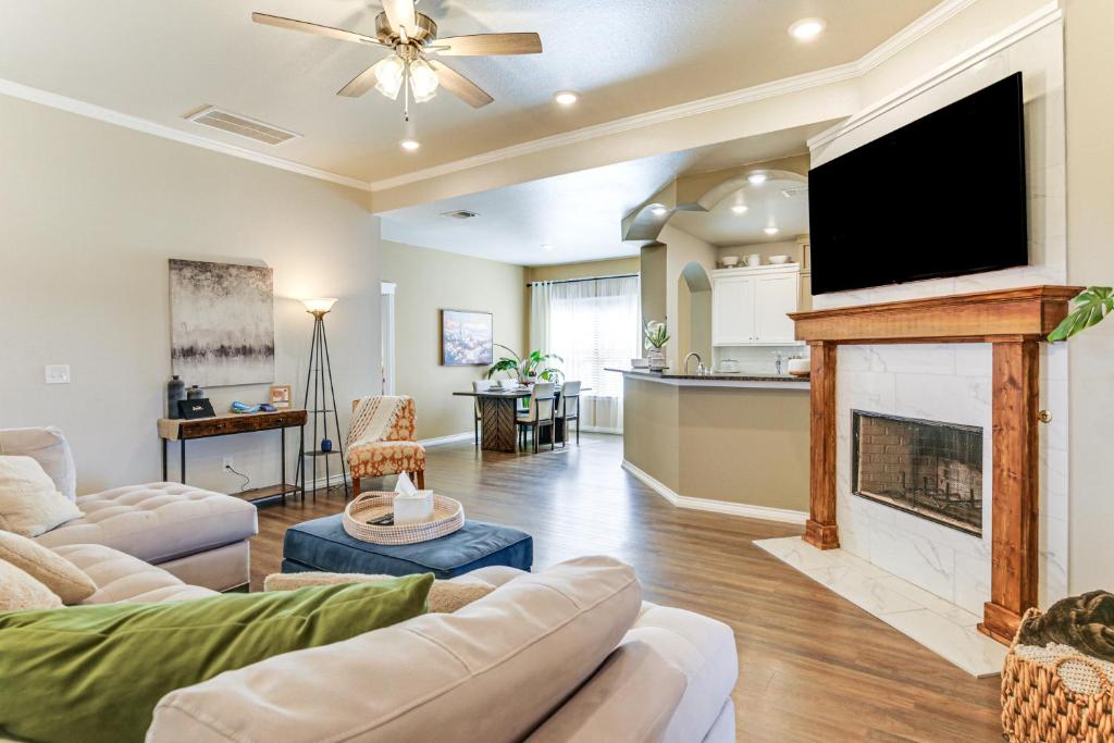 a living room with a fireplace and a flat screen tv at 11 Mi to Texas Tech University Cozy Family Home! in Wolfforth
