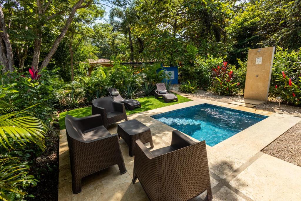 a backyard with a pool with chairs and a swimming pool at Casa Blue Monkey - Playa Conchal in Brasilito