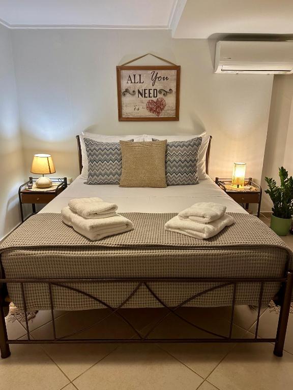 a bed in a room with two towels on it at Adrianas Central Stay in Patra