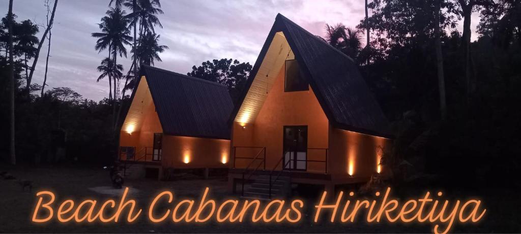 a house with lights in front of it at night at Beach Cabanas Hiriketiya in Hiriketiya