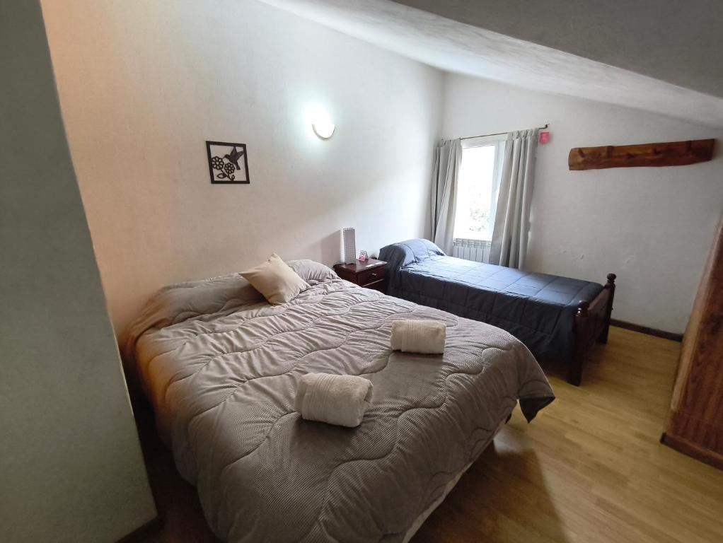 a bedroom with a bed with two towels on it at B&B Copahue in San Carlos de Bariloche