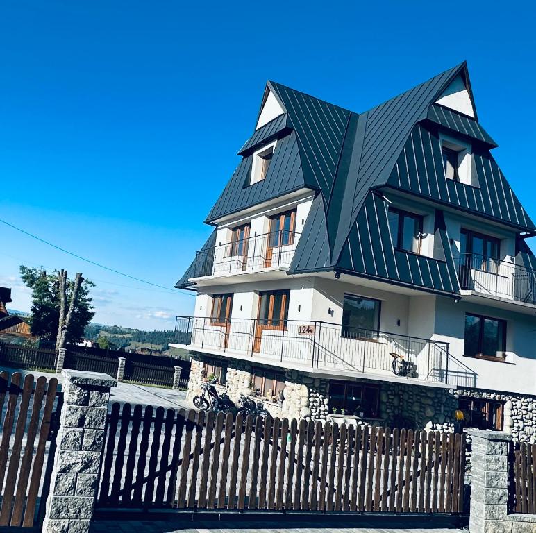 a black and white house with a black roof at Apartamenty 1000m npm Murzasichle in Murzasichle