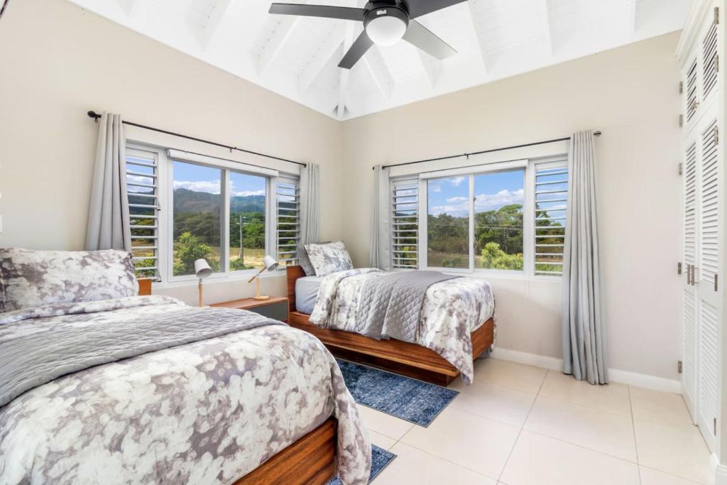 Un dormitorio con dos camas y dos ventanas. en 3rd Floor Condo wMountain Views - Beach Access - Pool), en Richmond