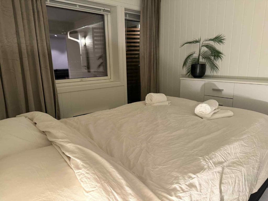 a bedroom with a white bed with two towels on it at Northern Lights View Beautiful Berg in Kuberg