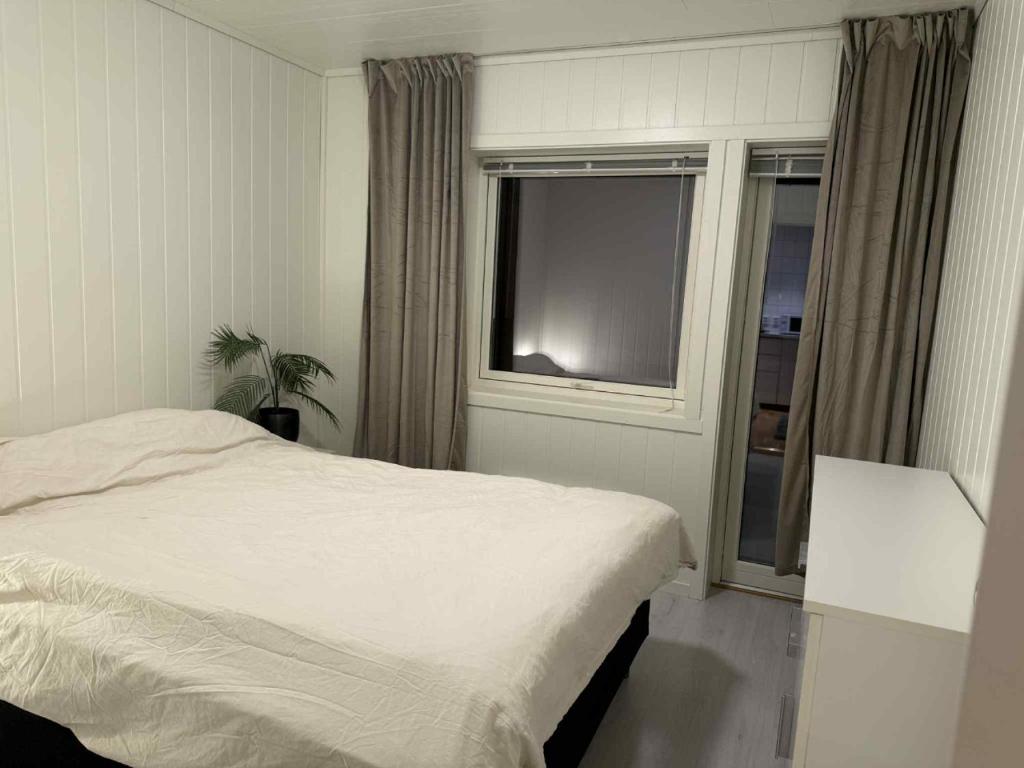 a bedroom with a white bed and a window at Northern Lights View Beautiful Berg in Kuberg