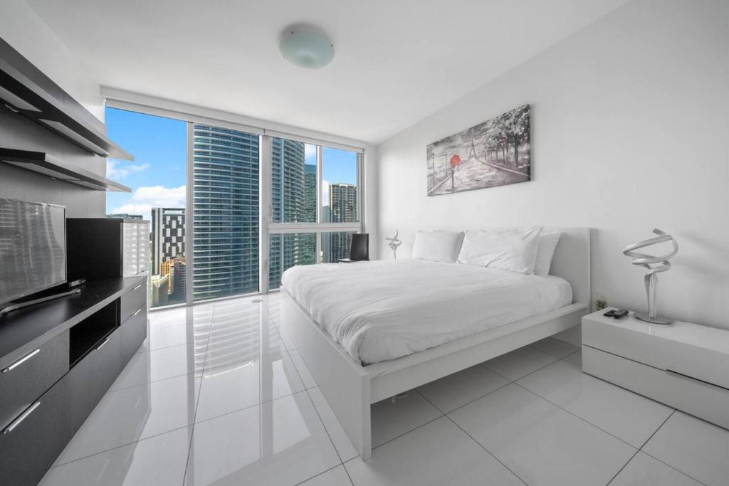a white bedroom with a bed and a large window at W Miami - LUXURY condo Amazing Views in Miami
