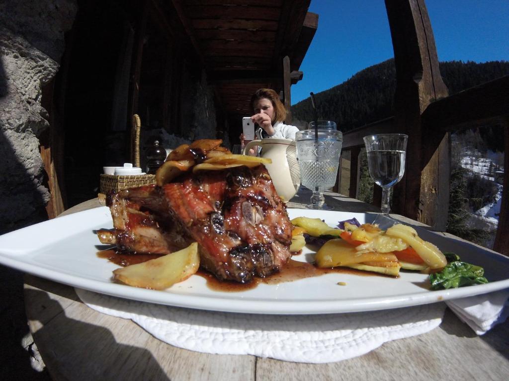 a plate of meat and vegetables on a table at Arpege Des Neiges in Sainte-Foy-Tarentaise
