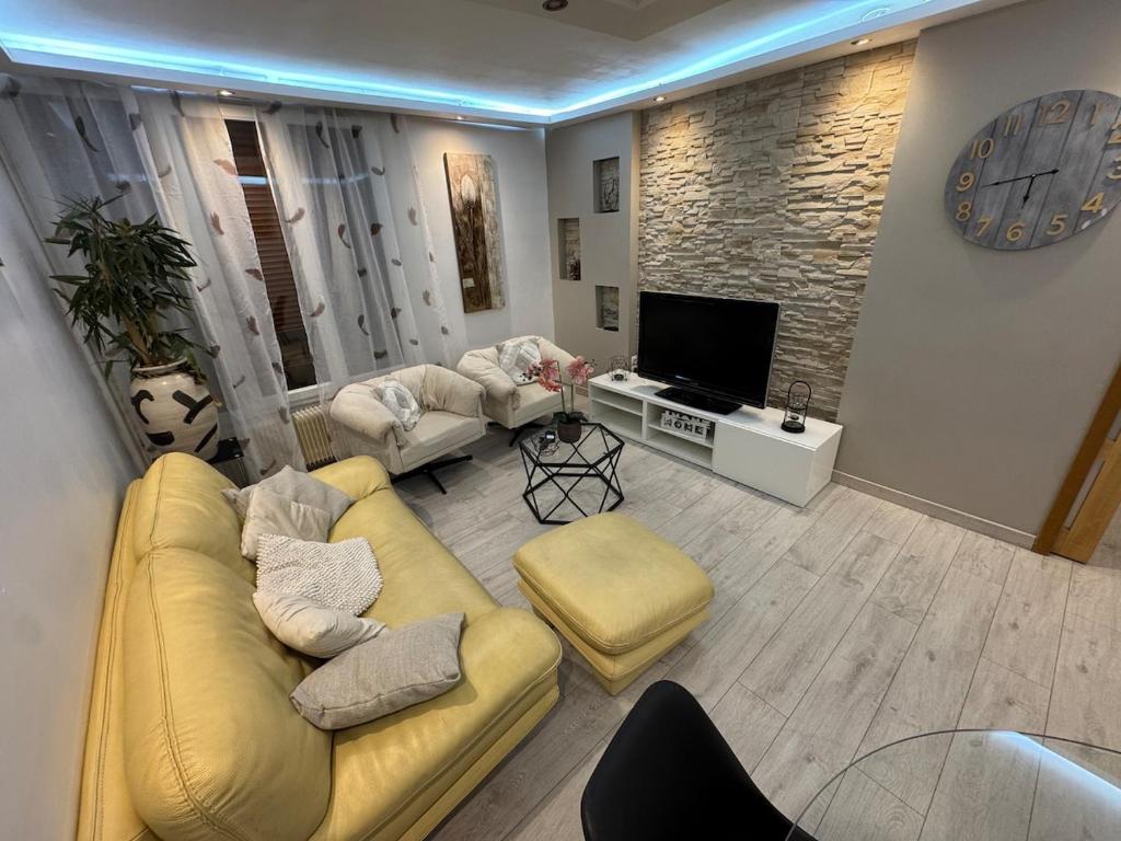 a living room with a yellow couch and a television at Appartement lumineux centre in Beauvais