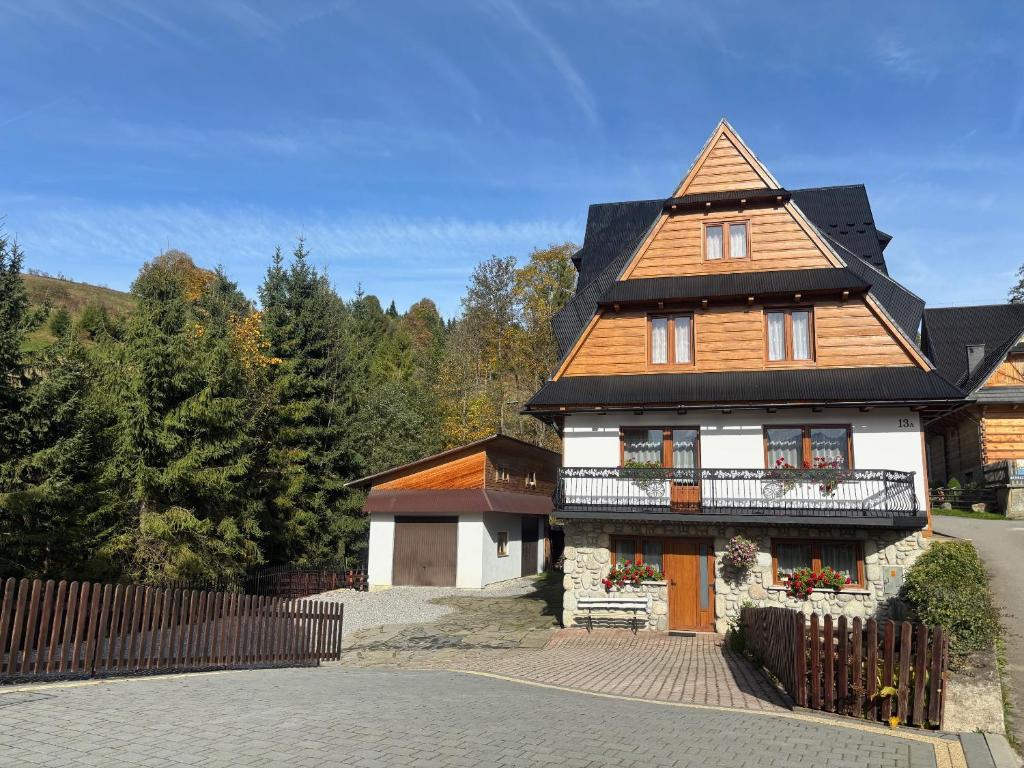 ein großes Haus mit einem Walmdach an einer Straße in der Unterkunft Ludwina Żegleń Pokoje Gościnne in Małe Ciche