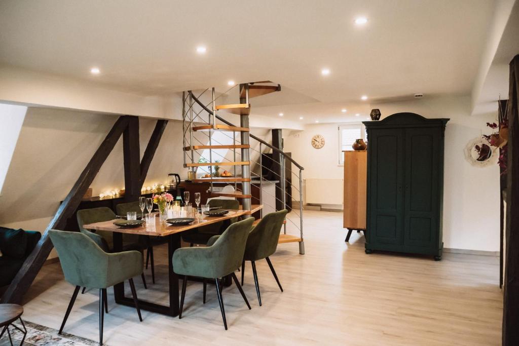 a dining room with a table and green chairs at Ferienwohnung Ella in Dinkelsbühl