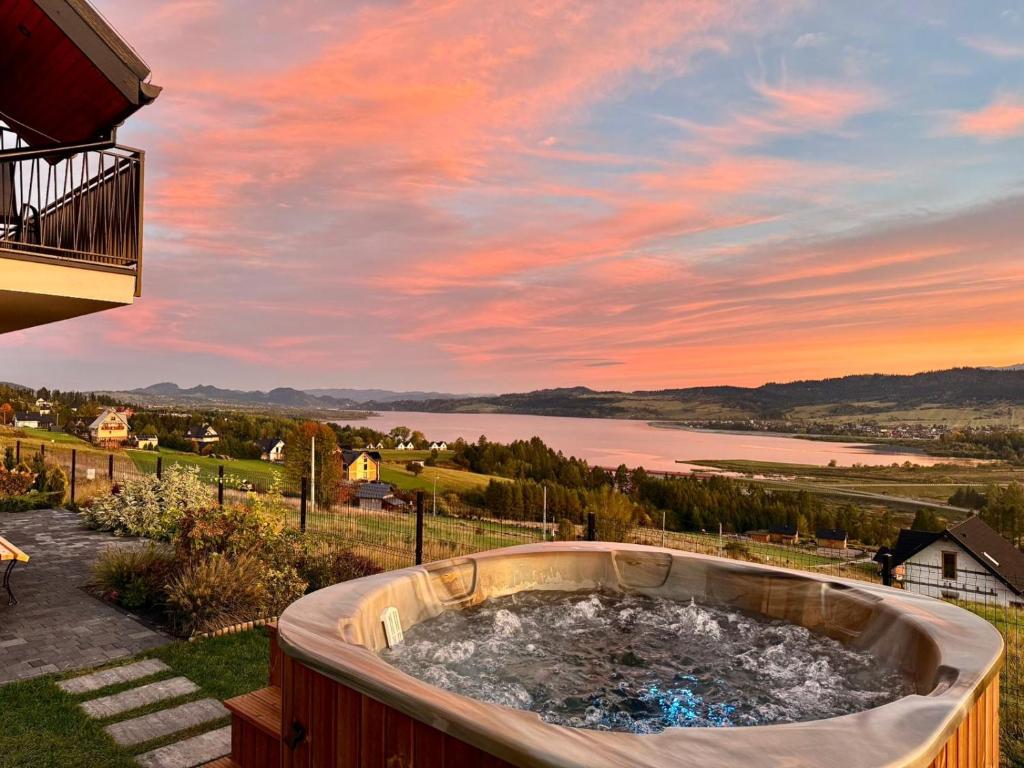 a hot tub on a deck with a view of a lake at Widokowa 16 in Szlembark