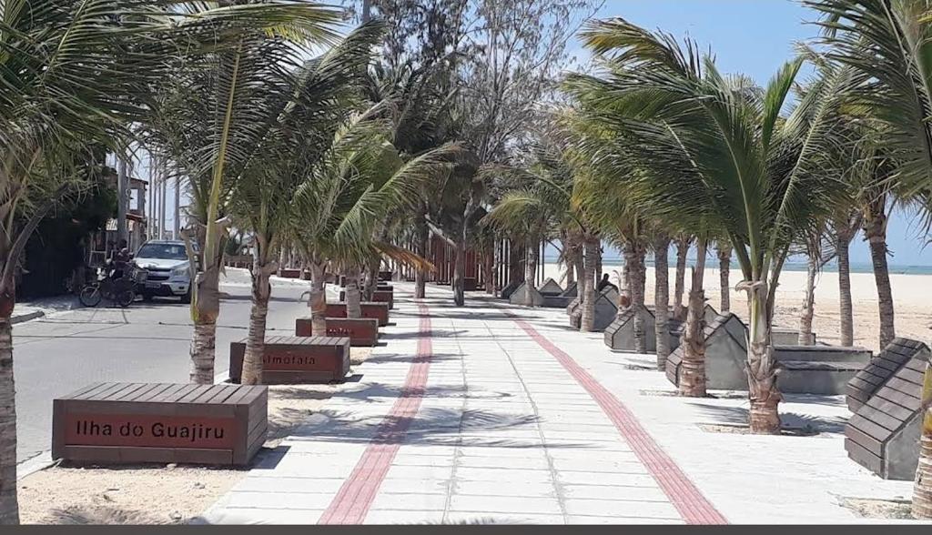 a sidewalk with palm trees on the beach at Pousada Paraíso das Dunas in Bitupitá