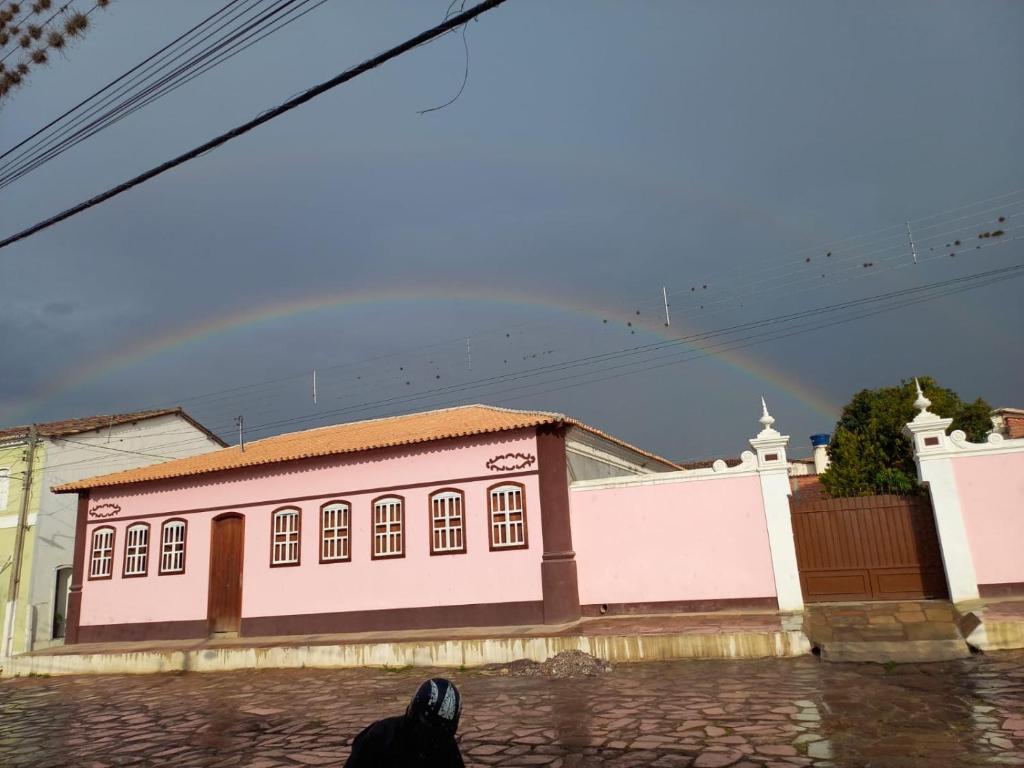 una persona sentada frente a un edificio rosa en Casa Rosada temporada em Rio de Contas, en Rio de Contas