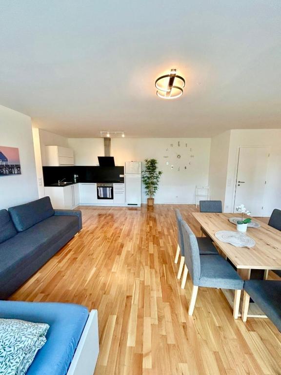 a living room with a wooden table and blue chairs at Spacious Modern Apartment with Free Parking in Gerasdorf bei Wien