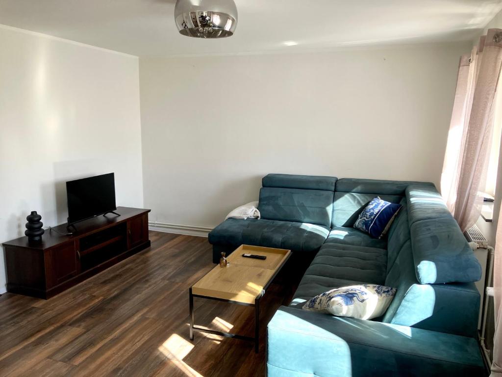 a living room with a blue couch and a table at Apartment Versteck am Hug in Jüterbog