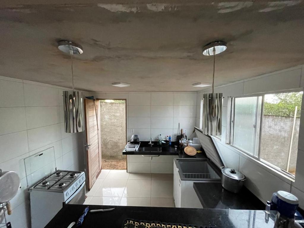 une cuisine avec un évier et une cuisinière four supérieur dans l'établissement Casa Linda Barrerinhas - Ma, à Barreirinhas