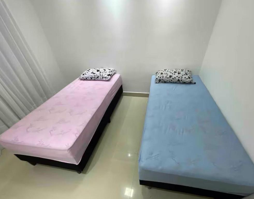 two beds are sitting in a room withermottermottermott at Seu Refúgio em São Luís MA in São Luís