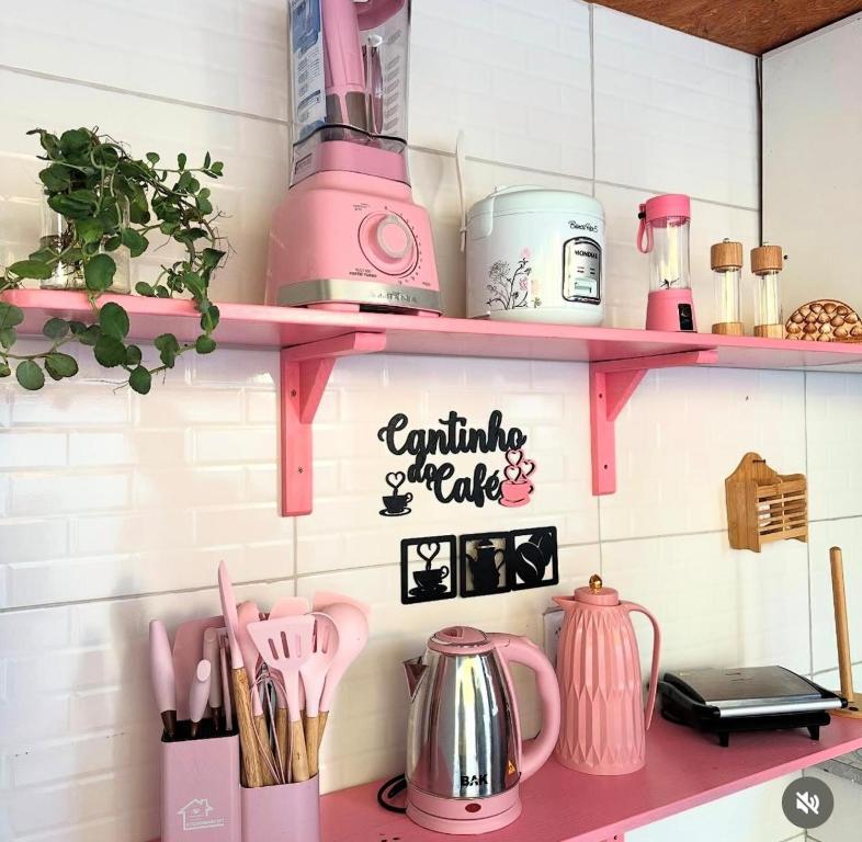 a pink kitchen shelf with pink appliances on it at Na Casa Delas Jericoacoara in Jericoacoara