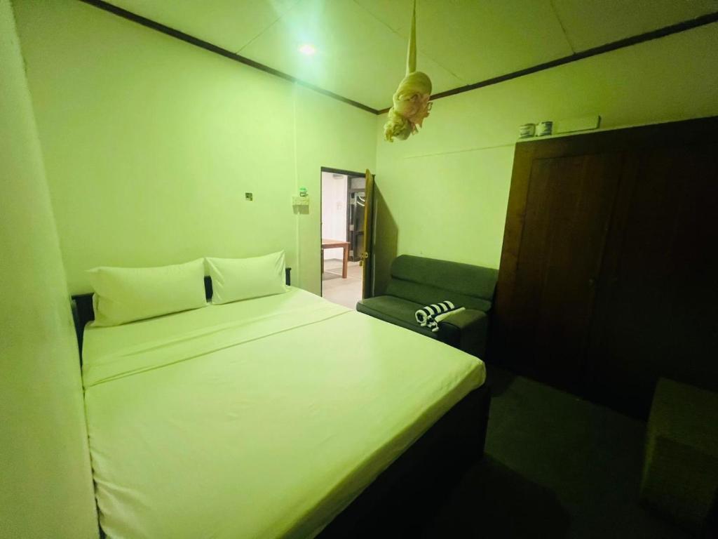 um quarto com uma cama branca e um sofá em Sun and Moon spa em Tangalle