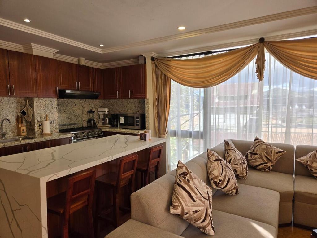 a living room with a couch and a kitchen at Hilltop Bellavista, Suite Three, the best choice in Cuenca