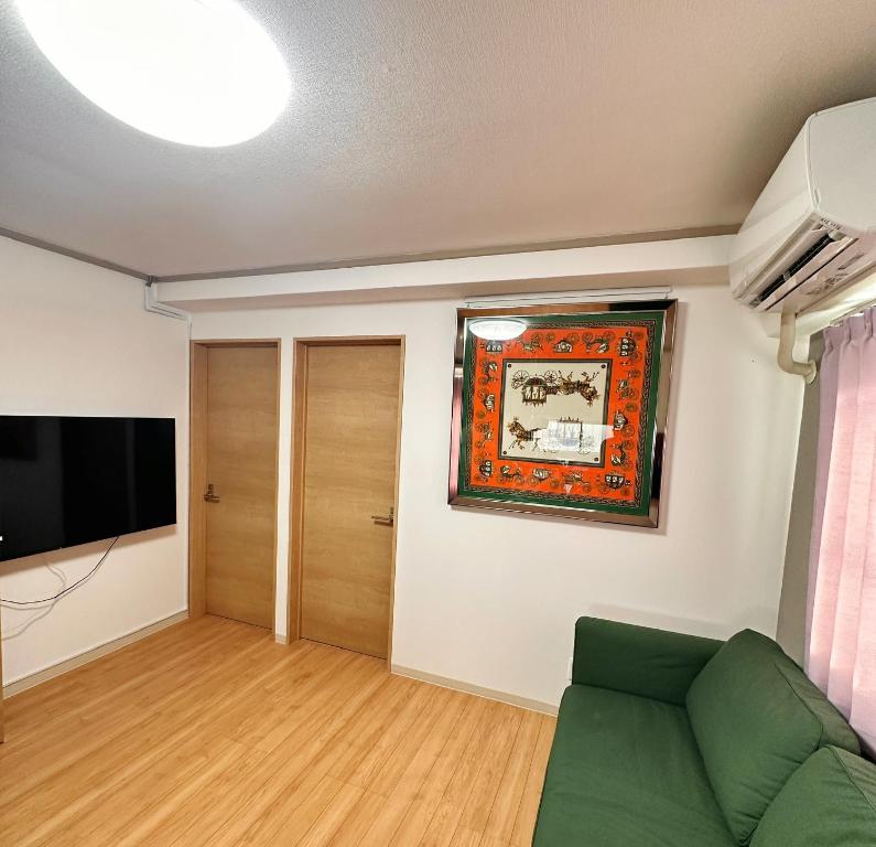 ein Wohnzimmer mit Couch und Flachbildfernseher in der Unterkunft HYGGE HOUSE Tabibitonoie - Vacation STAY 61161v in Kashiwa