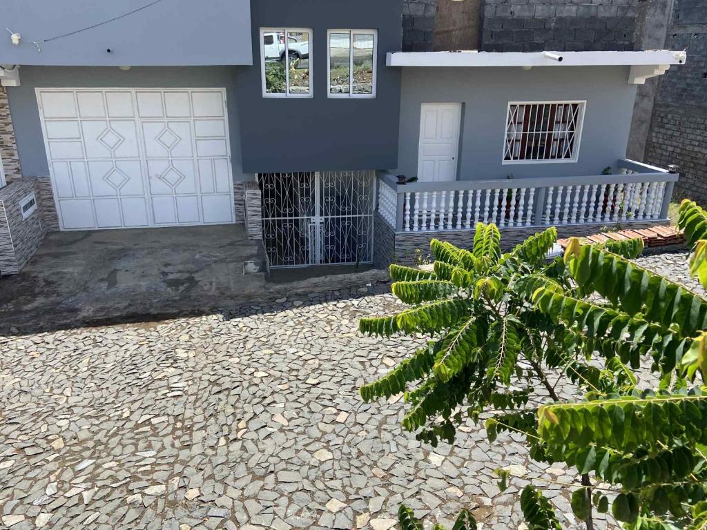 een blauw huis met een witte garage bij Casa Nova Montrond in São Filipe