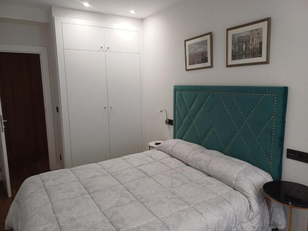 a bedroom with a bed with a green headboard at Apartamento con garaje en Valladolid in Valladolid