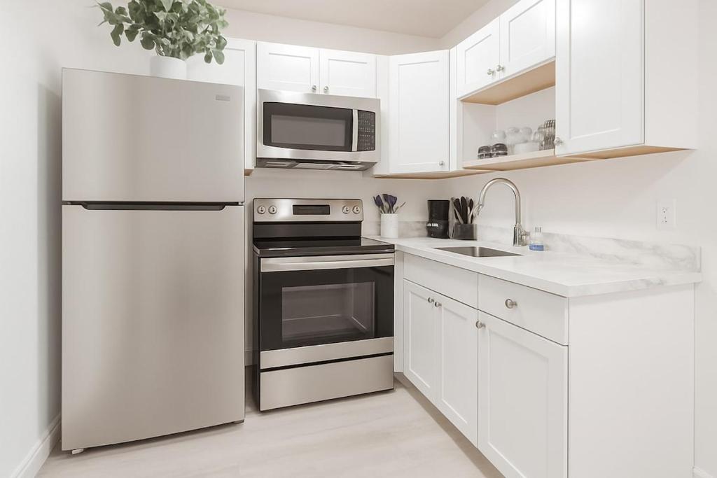 a white kitchen with a refrigerator and a sink at Relaxing Retreat in Sunny Bonita Springs in Bonita Springs