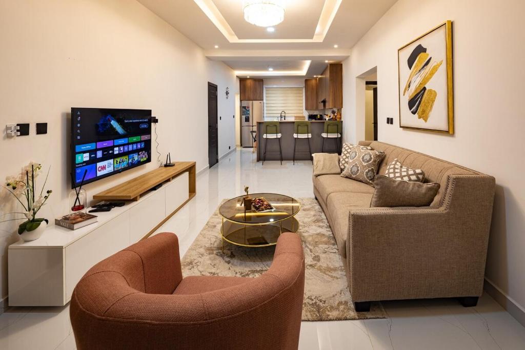 a living room with two couches and a tv at Greyasset Amber in Spintex