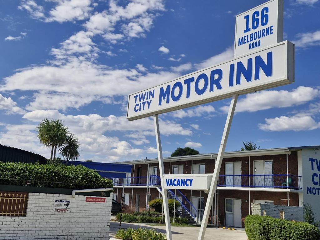 un letrero de la calle frente a un motel en Twin City Motor Inn, en Wodonga