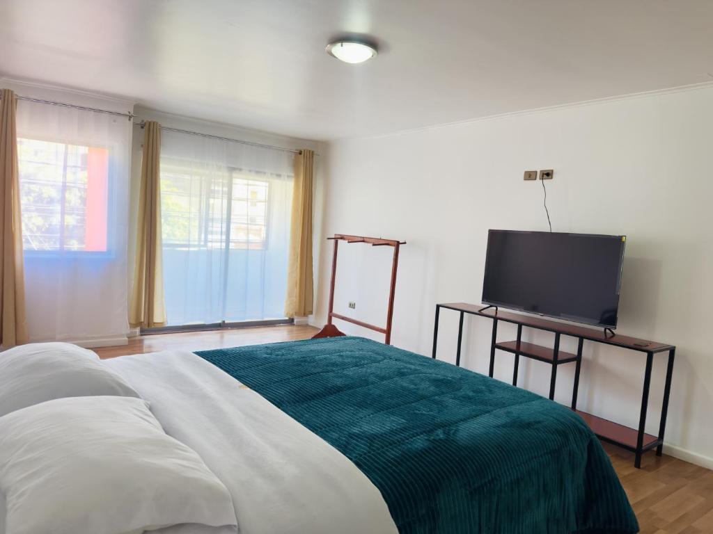 a bedroom with a bed and a flat screen tv at Hotel Atacama Copiapo in Copiapó