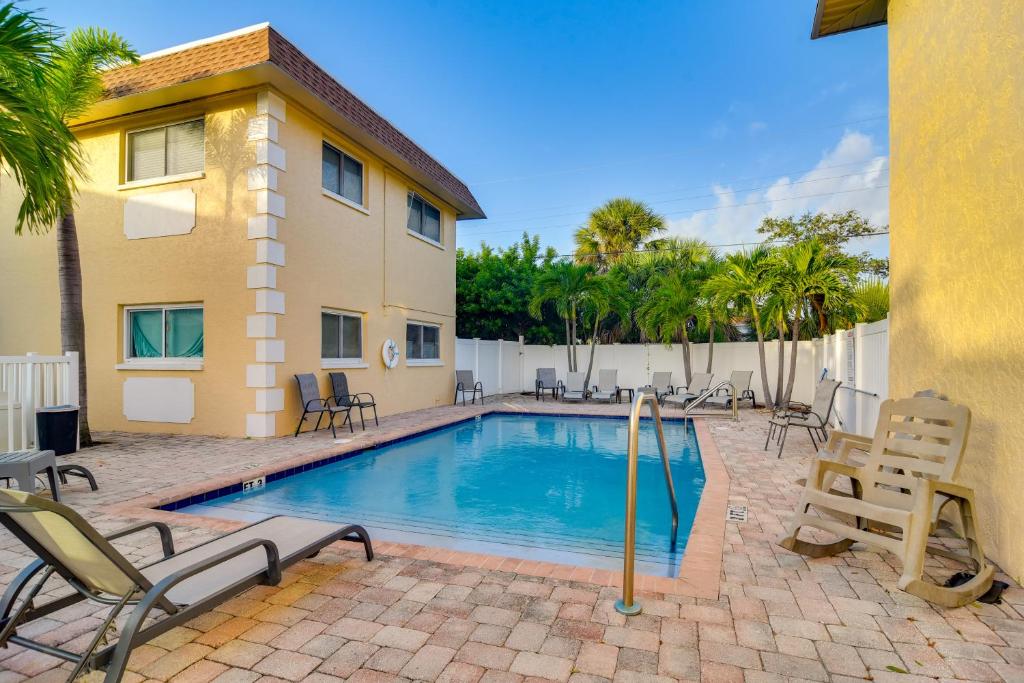 a swimming pool with chairs and a building at Near Beach! Modern Ground-Floor Condo in St Pete in St Pete Beach