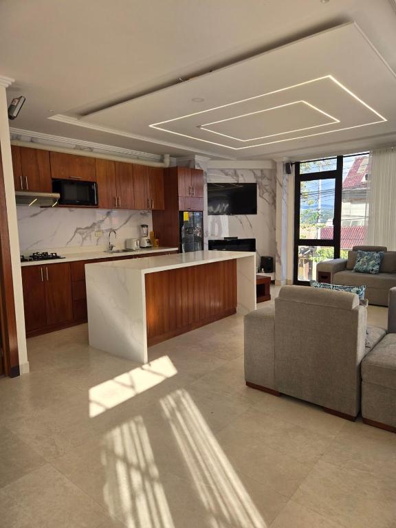 a kitchen and living room with a couch and a table at La suite del ensueño in Cuenca