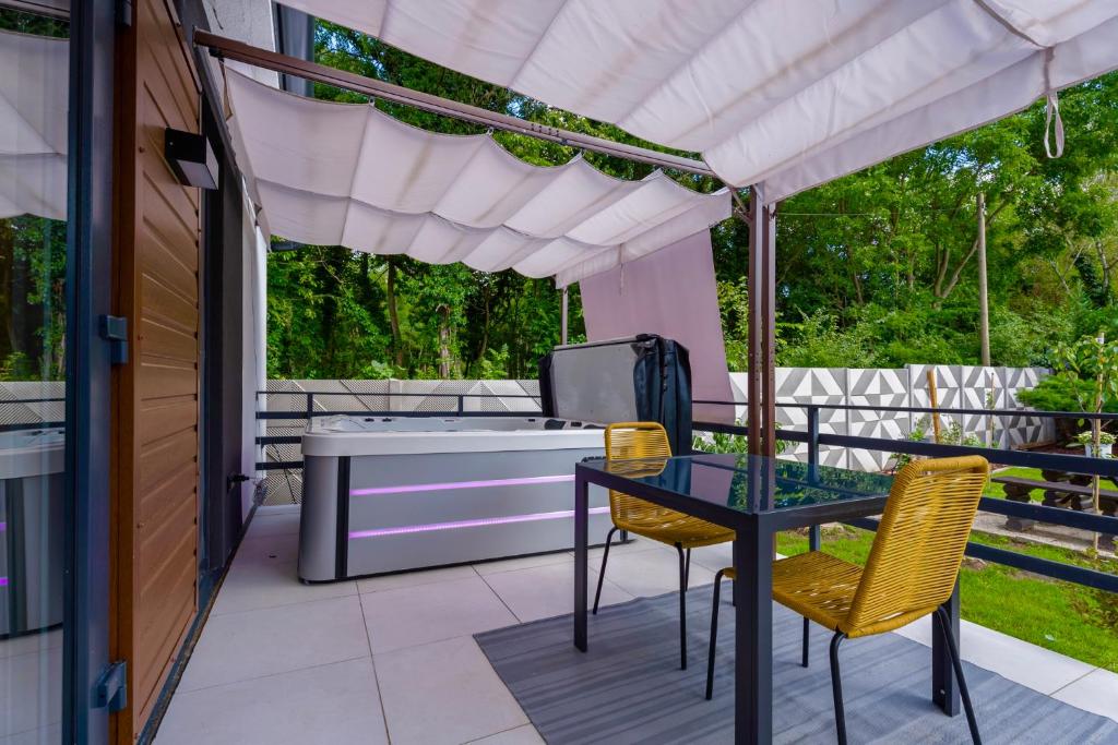 a patio with a tub and a table and chairs at Patrikabin in Tata