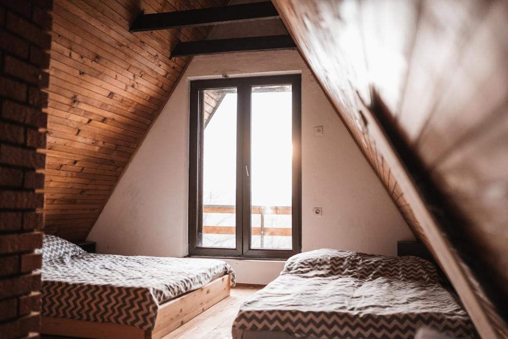 Dos camas en una habitación con ventana. en Forrest House, en Doboj