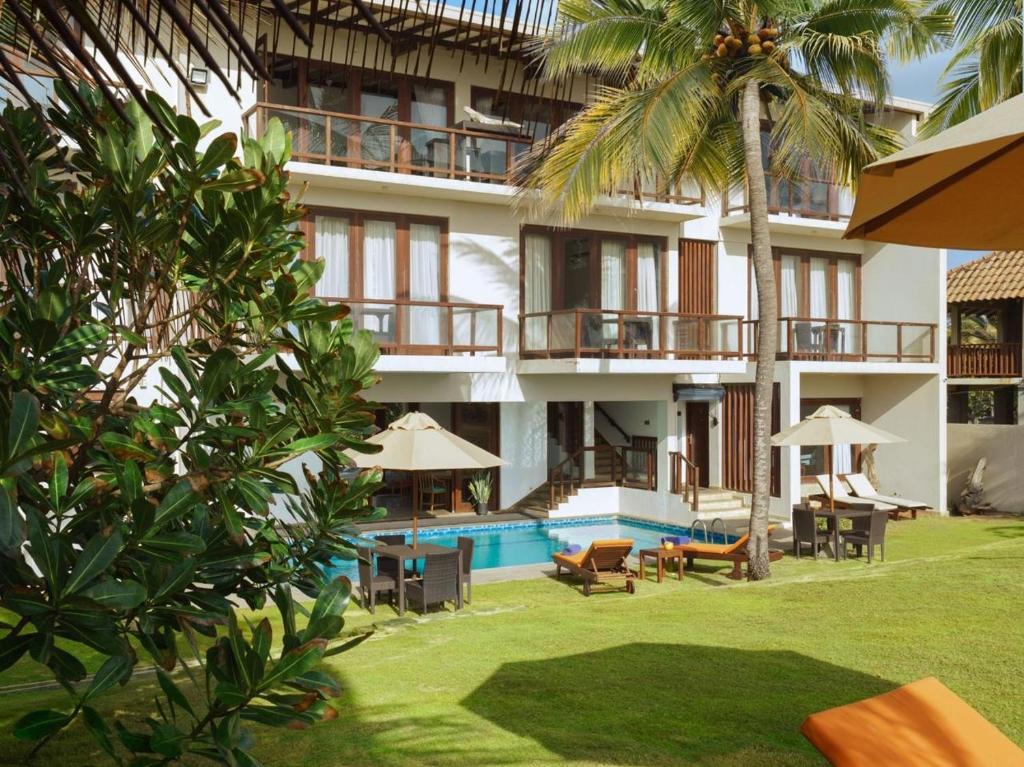 a building with a swimming pool and a resort at Driftwood Villa in Pamunugama