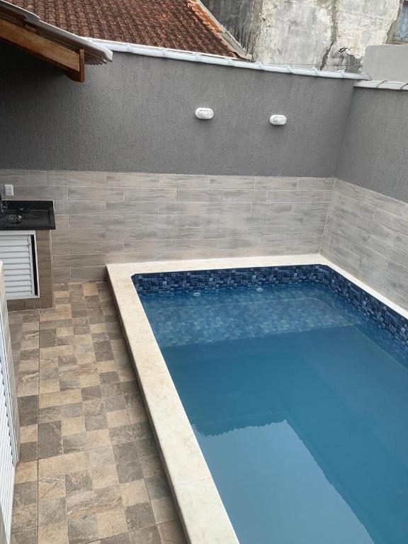 a swimming pool in a backyard with a tile floor at ótima casa em Itanhaém in Itanhaém