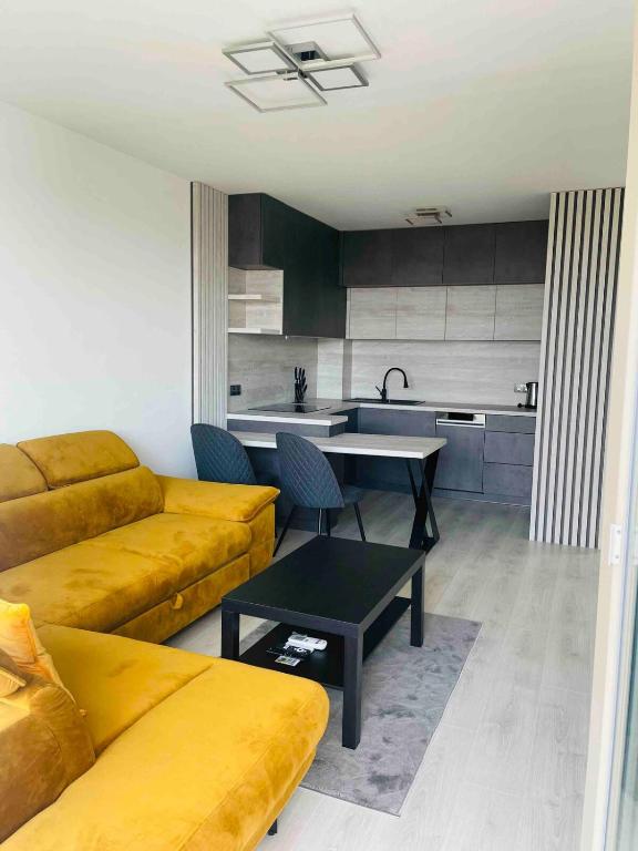 a living room with a couch and a kitchen at Moruse airport apartment in Prievoz