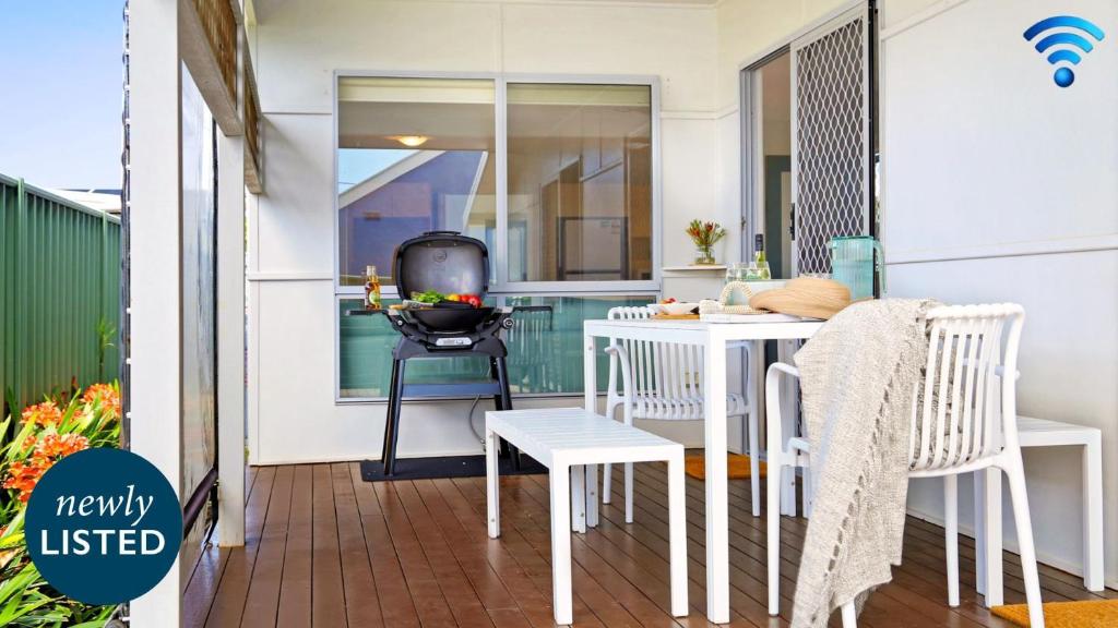 a small balcony with a white table and chairs at Rockpool Retreat in Currarong