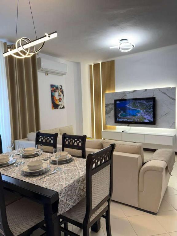 a living room with a table and chairs and a couch at GES Apartment in Elbasan