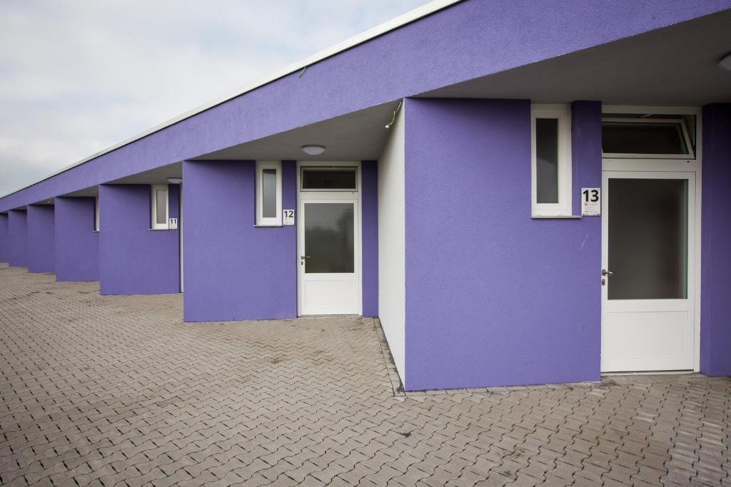 a row of purple buildings with white doors at MOTEL Schlegel in Erwitte
