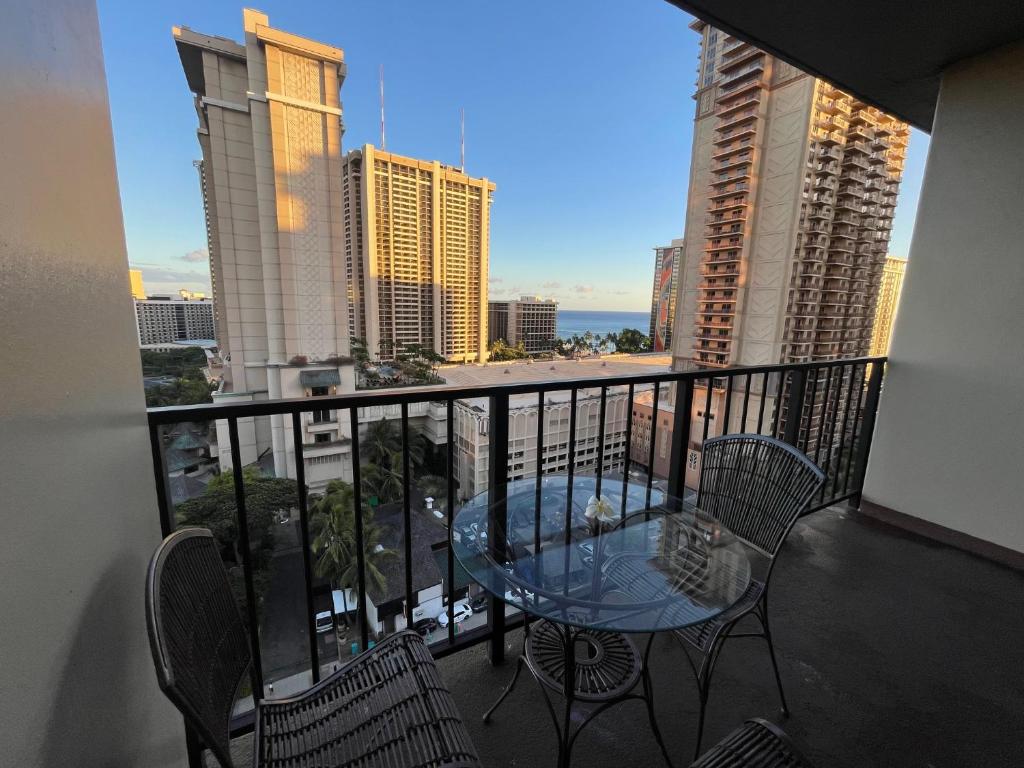 a balcony with a table and chairs and a view of the city at Palms at Waikiki in Honolulu