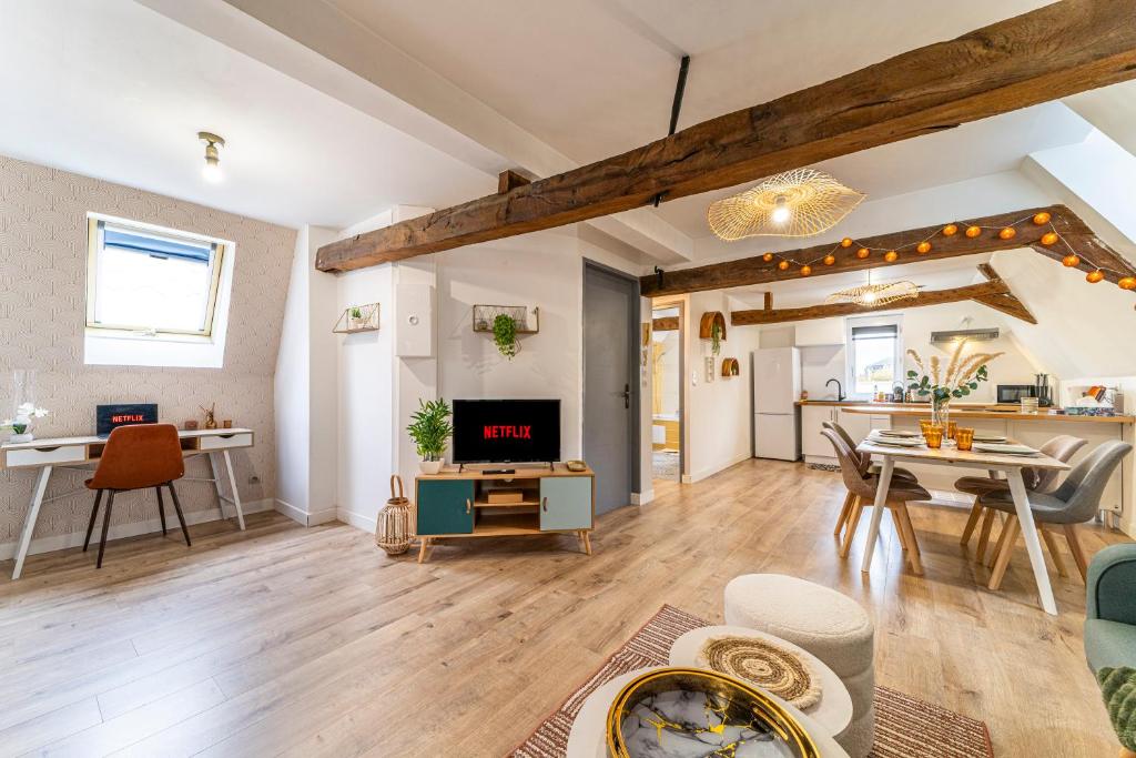 a living room with a table and a dining room at Le Nid - Hypercentre - 3 beds - Wifi - Netflix in Cambrai