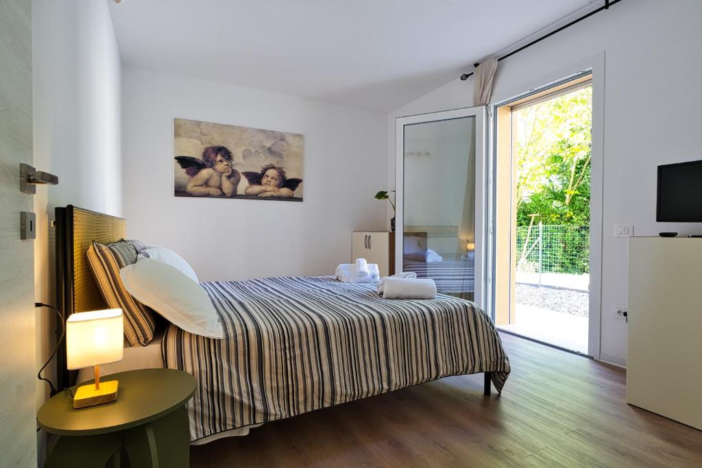 a bedroom with a bed and a sliding glass door at Margherita Luxury Resort near Venice in Santo Stino di Livenza